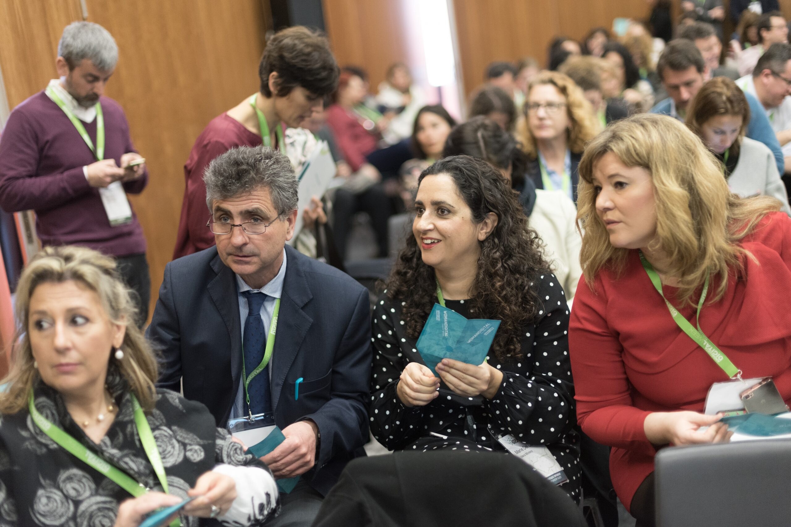 Algunas personas en la charla doblan la página de un folleto para hacer un avión de papel