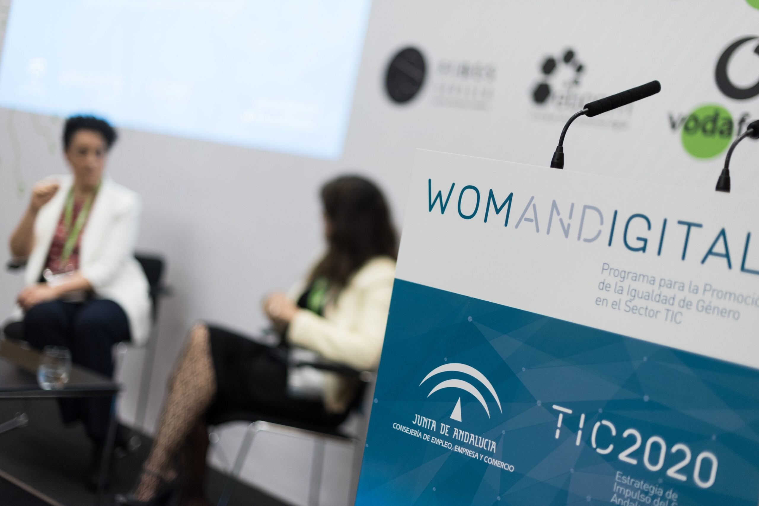 Dos mujeres hablando tras un atril