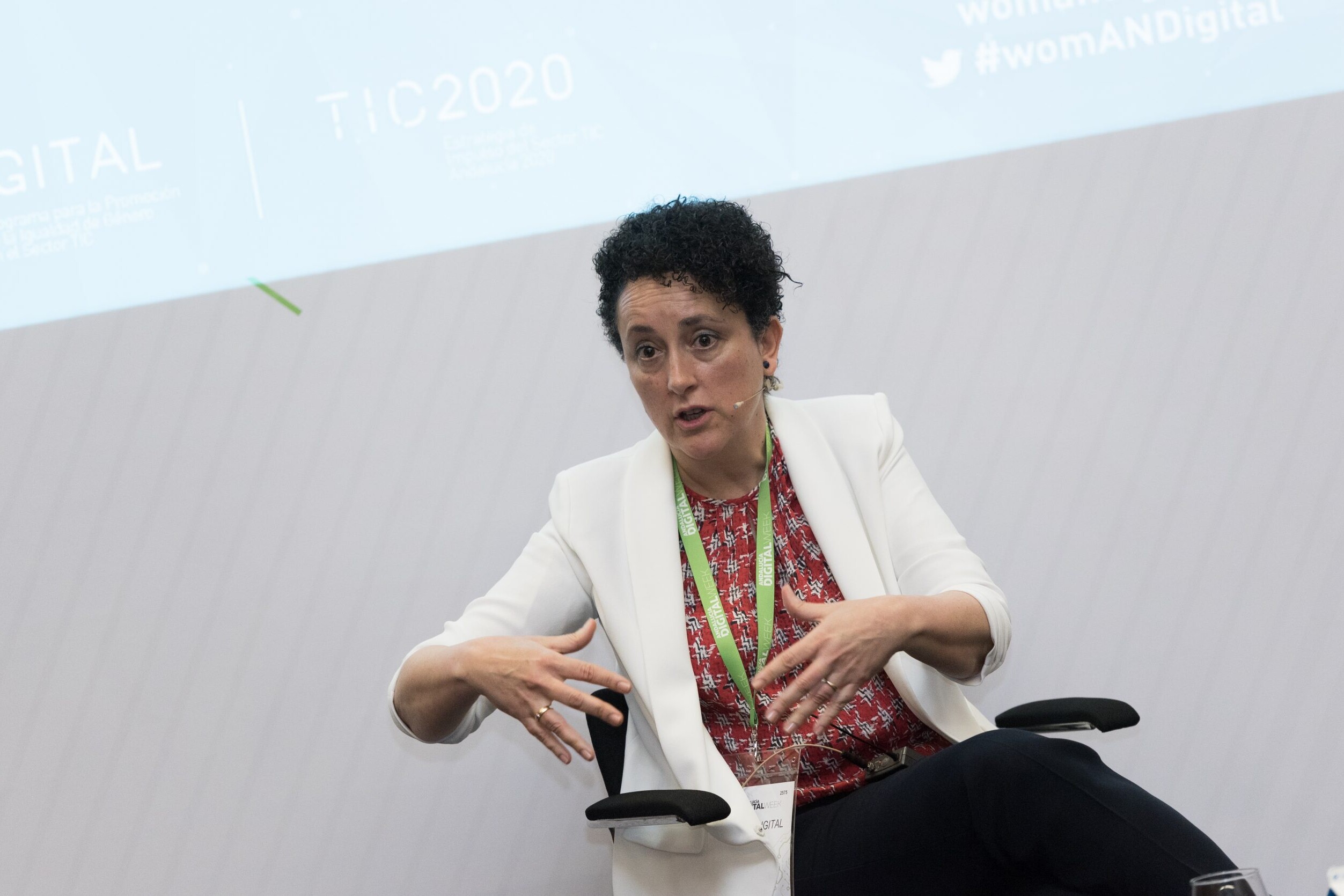 Una mujer sentada habla gesticulando con las manos