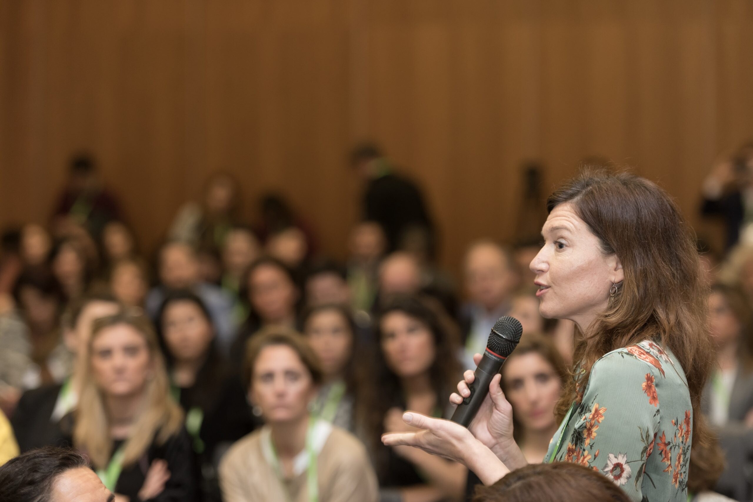 Una mujer del público hablando con un micrófono