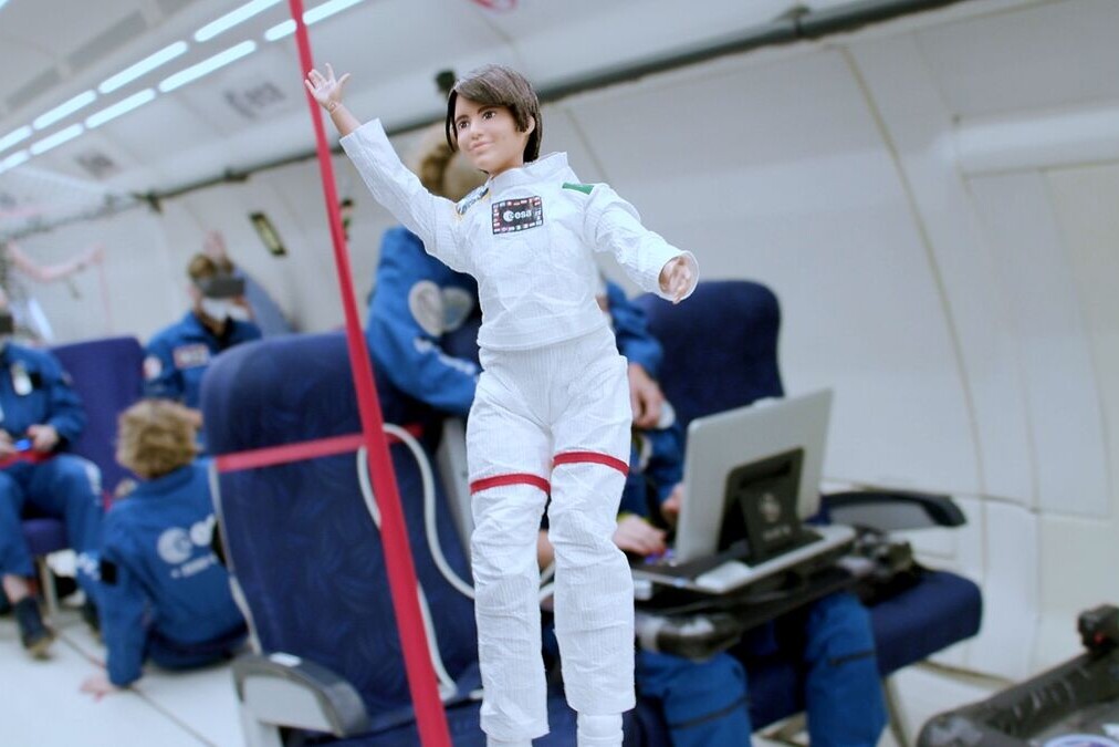 muñeca vestida de astronauta sin gravedad dentro de un avion