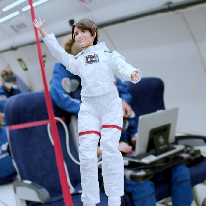 muñeca vestida de astronauta sin gravedad dentro de un avion