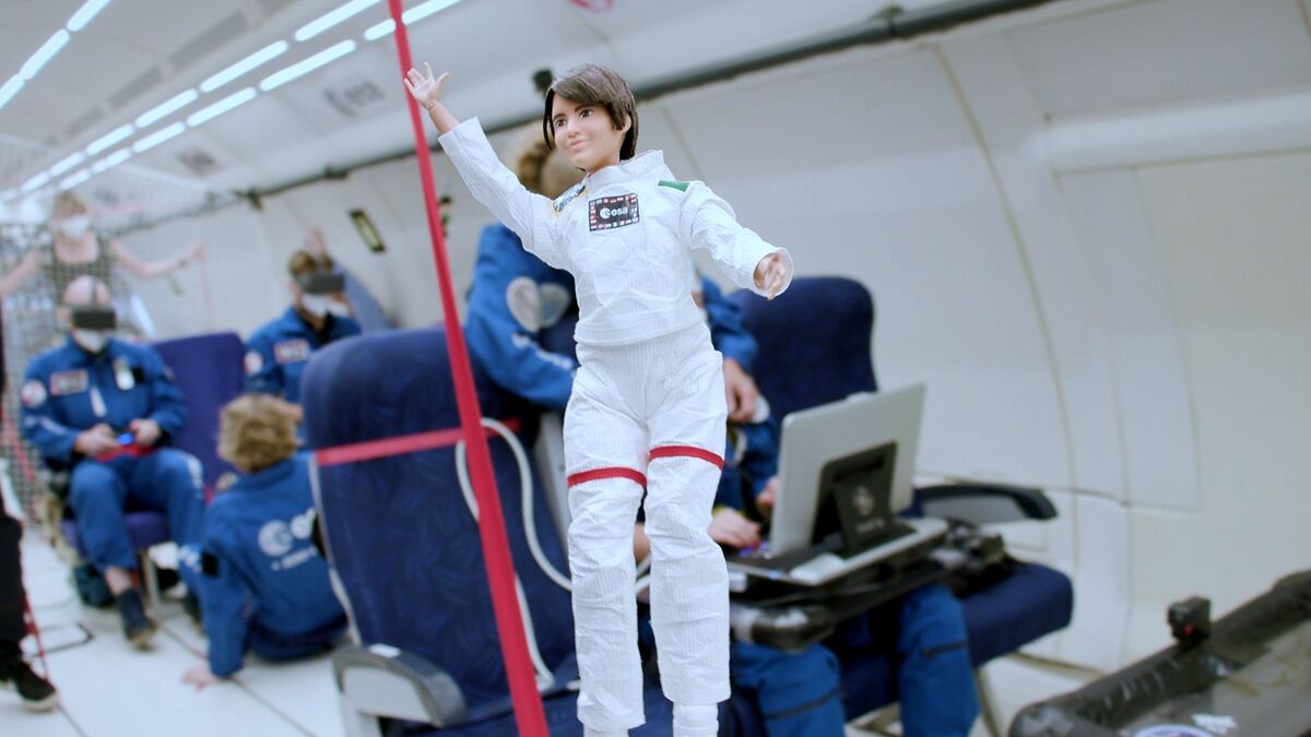 muñeca vestida de astronauta sin gravedad dentro de un avion
