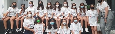 Grupo de alumnas posando con mascarillas y camisetas con slogan 