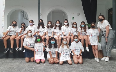 Grupo de alumnas posando con mascarillas y camisetas con slogan 