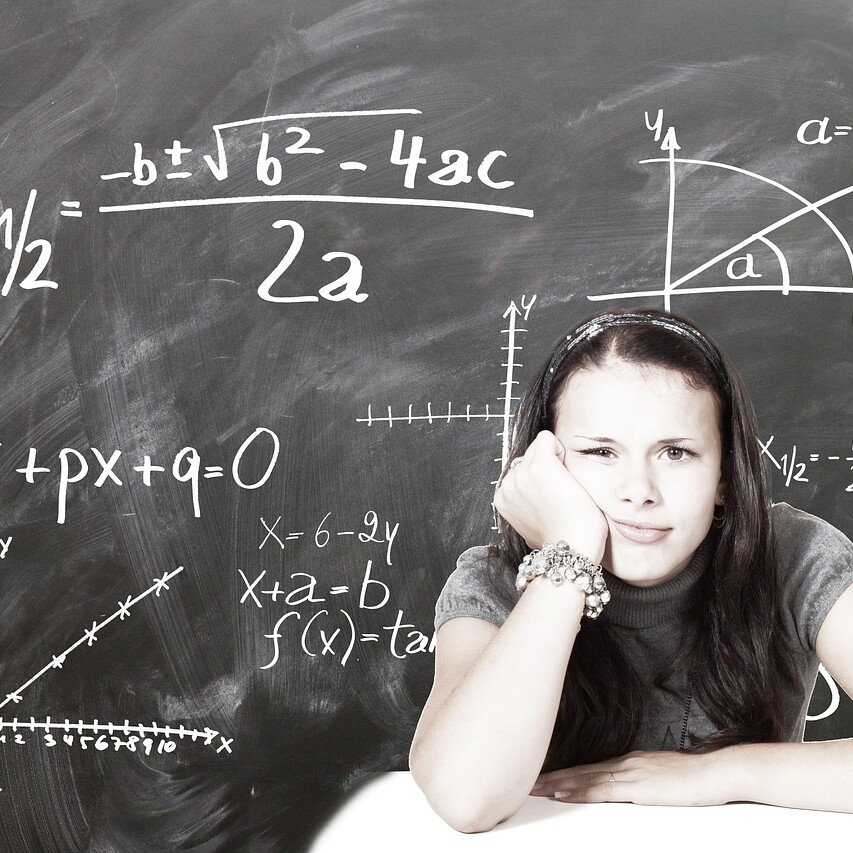 niña pensativa frente a una pizarra con fórmulas matemáticas