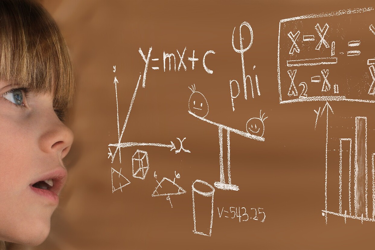Vemos una niña mirando una ecuación dibujada con tiza